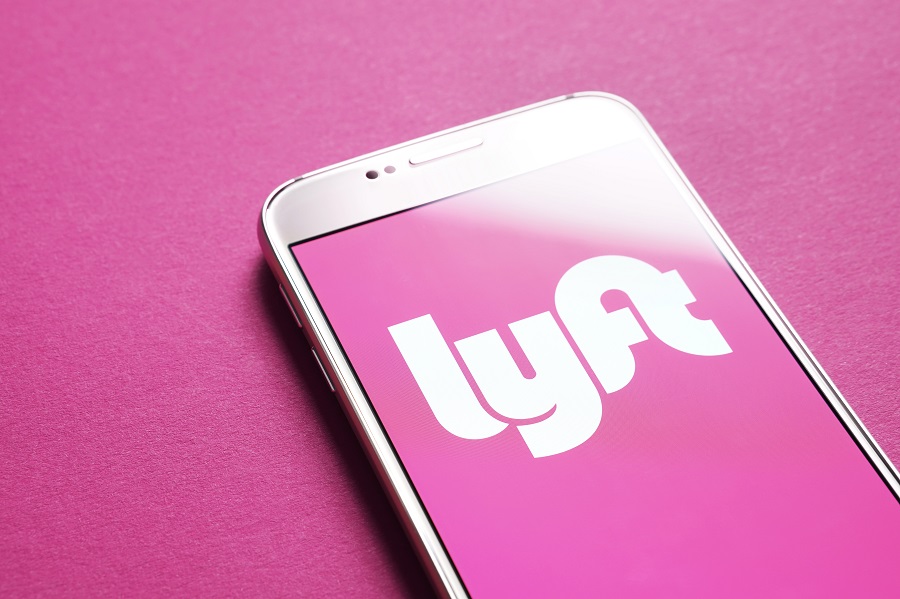 Lyft logo displayed on phone screen over a pink background
