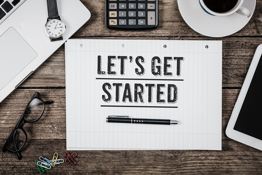Desk with a notebook that shows "Let's Get Started"