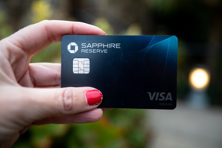 Woman with red nails holding a Chase Sapphire Reserve credit card