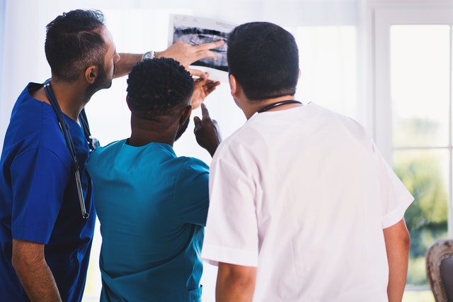 Three people looking at x-ray results