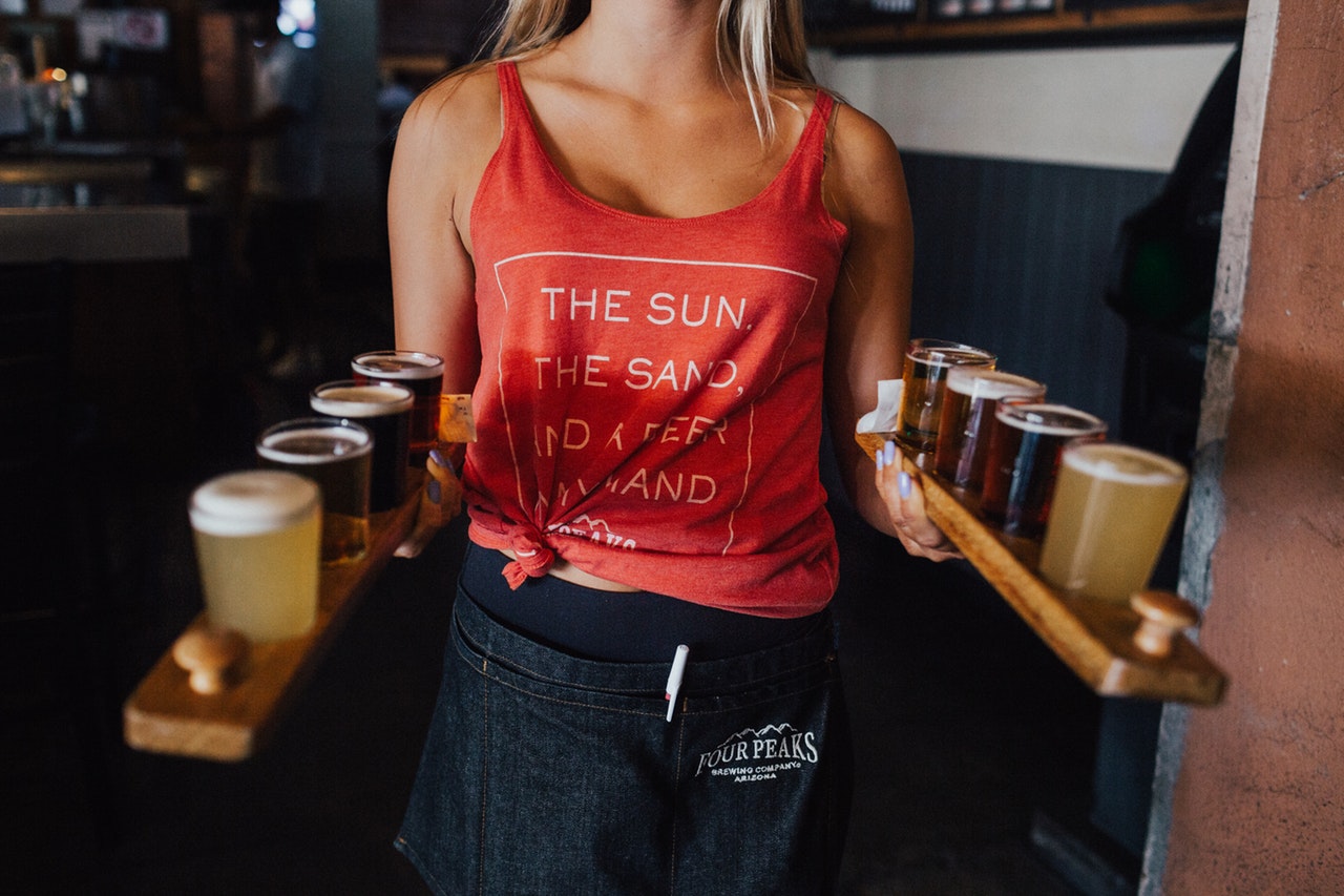 Waitress in tank top holding two beer trays