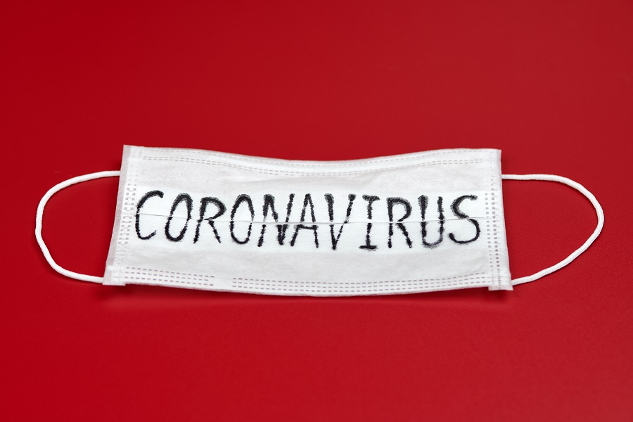 Coronavirus written on a mask over red background