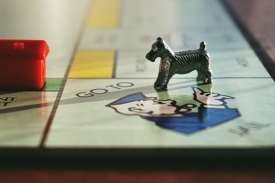Dog and house toy on monopoly board game