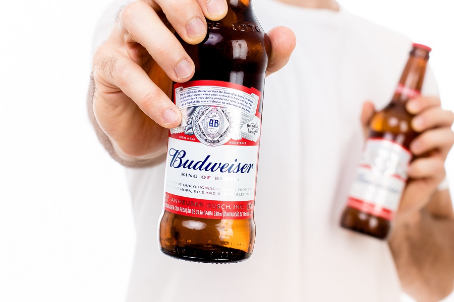 Man holding Budweiser glass bottle with white background