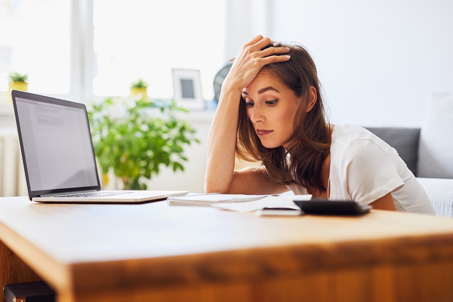 Young woman struggling looking at bills