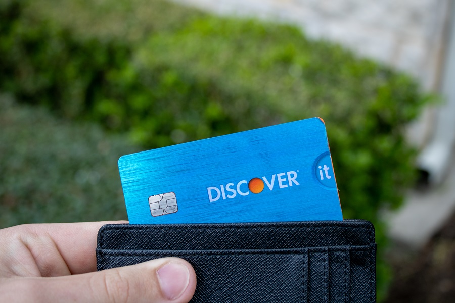 Man holding Discover It card inside wallet