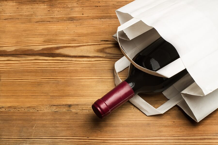 Bottle of wine in white bag hero image