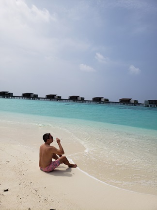 John sitting on the beach at Park Hyatt Hadahaa in Maldives